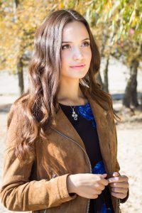 Portrait of young beautiful brunette woman in park on a sunny autumn day